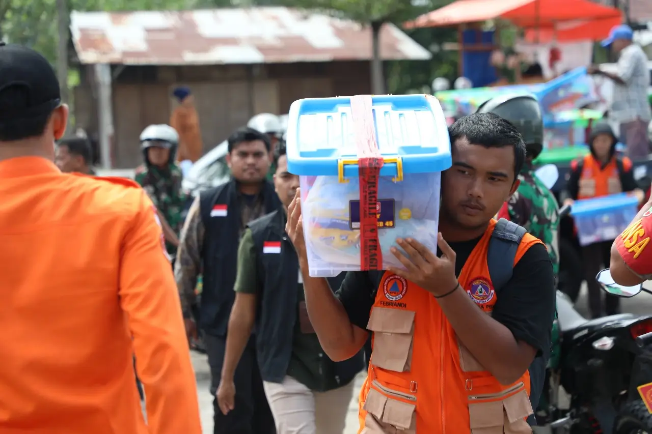 Seorang anggota BPBD Provinsi Riau membawa bantuan hygiene kit dari BNPB untuk didistribusikan kepada warga terdampak banjir di Kecamatan Rumbai, Pekanbaru, Provinsi Riau, Kamis (17/1).